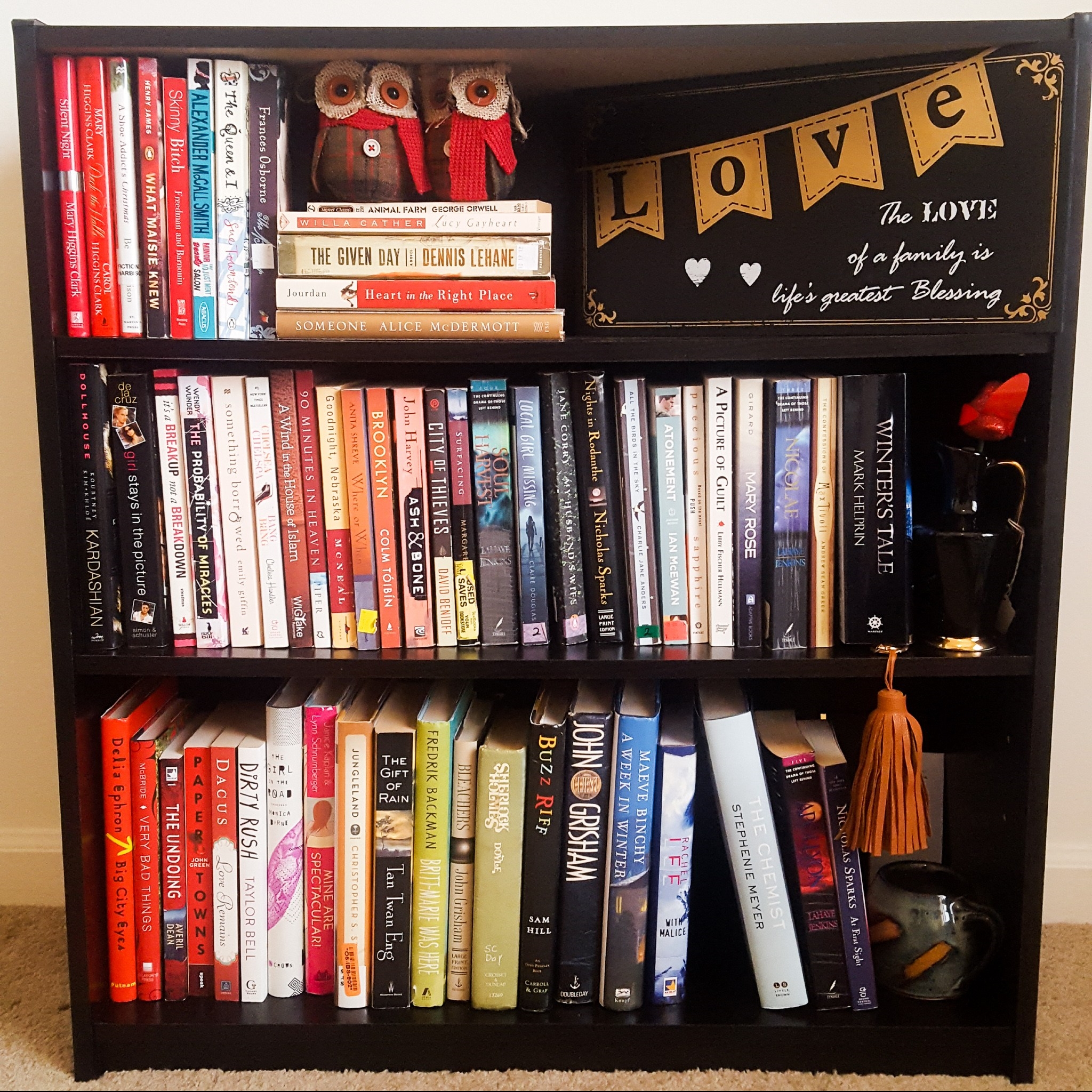 filled three-tier bookshelf